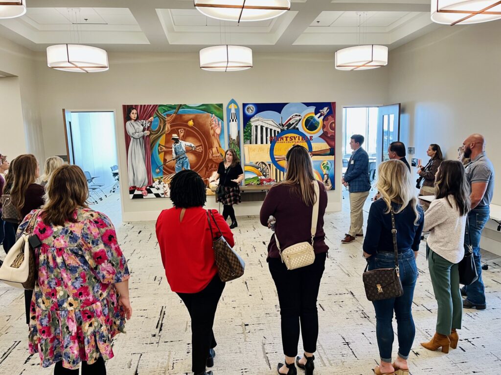 A photo of a tour group in front of a painting.